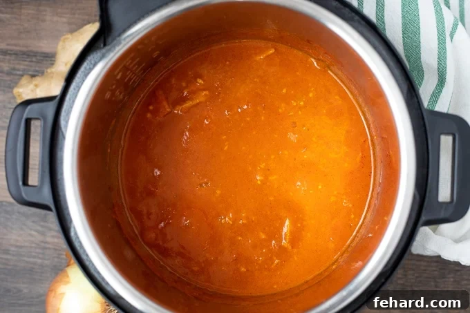 Butter Chicken for Instant Pot Creamy butter chicken simmering in the Instant Pot after heavy cream has been added.