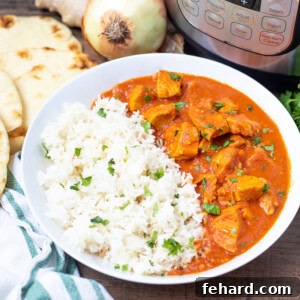 Bowl of Instant Pot Butter Chicken with rice next to Instant Pot