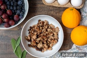 Cooked Ground Breakfast Sausage in white bowl next to fruit.