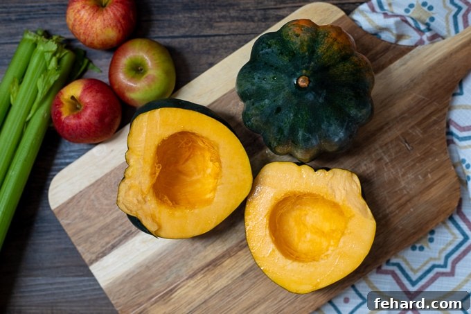 Acorn squash halves, perfectly cut open on a wooden cutting board, ready for roasting.