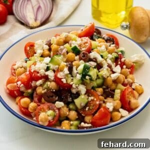 Chickpea salad with feta and olives in blue bowl.