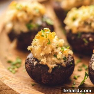 Sausage Stuffed Mushrooms with a crispy breadcrumb topping on a wooden serving platter.