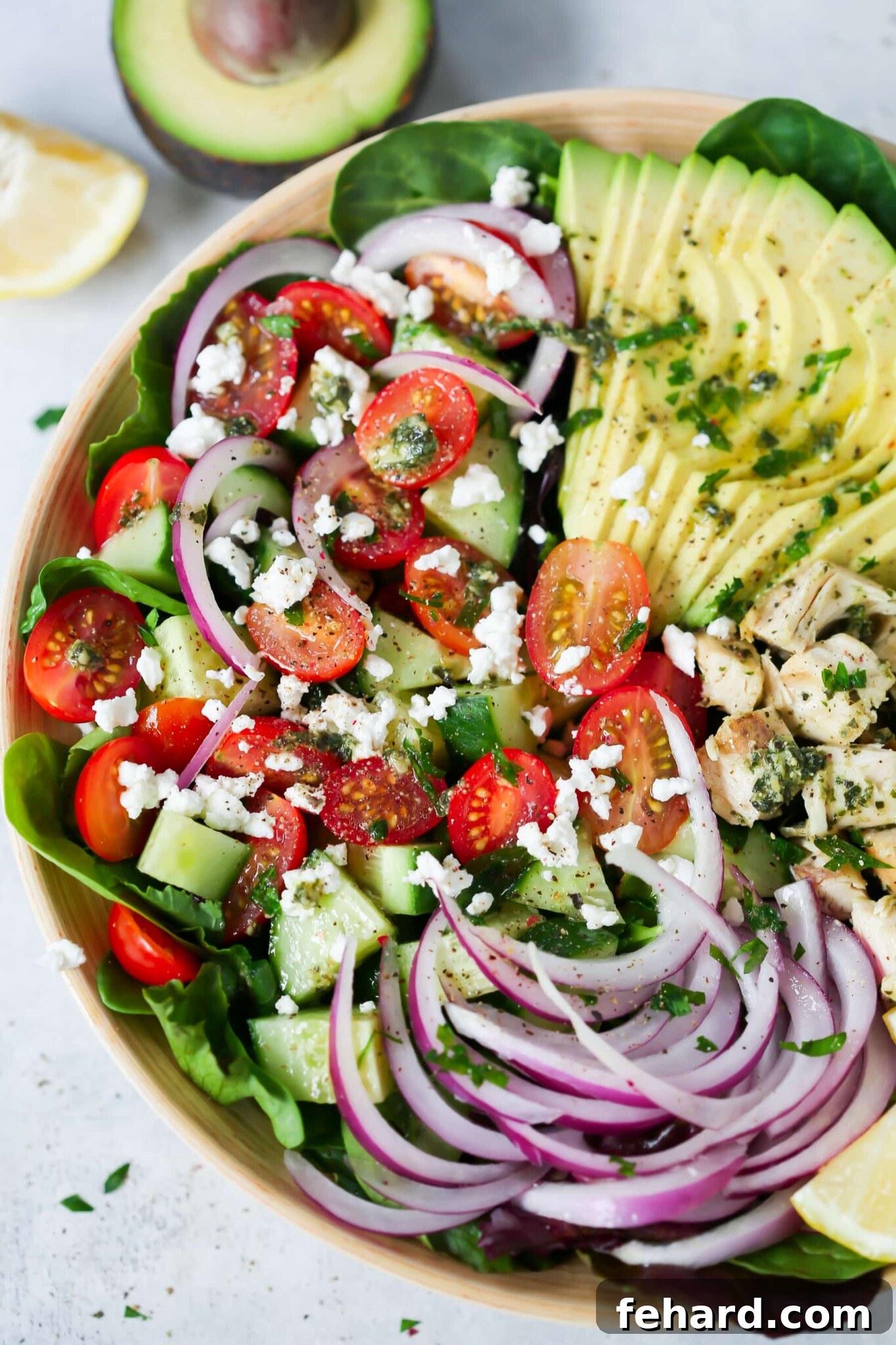 Pesto Chicken Salad - This healthy, easy, filling and super delicious Pesto Chicken Salad recipe is loaded with lettuces, cherry tomatoes, avocado, red onions and flavoured with a light lemon dressing. Another view of the delicious Pesto Chicken Salad in a bowl, ready to be served.