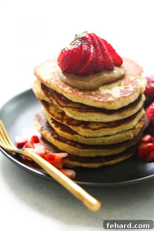 Stacked 3-Ingredient Almond Flour Pancakes with fresh fruit and almond butter drizzle