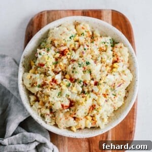 Overhead shot of cauliflower potato salad on on a wooden serving board