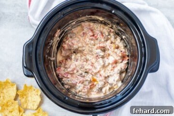 Cheesy sausage dip in slow cooker after cream cheese has melted.