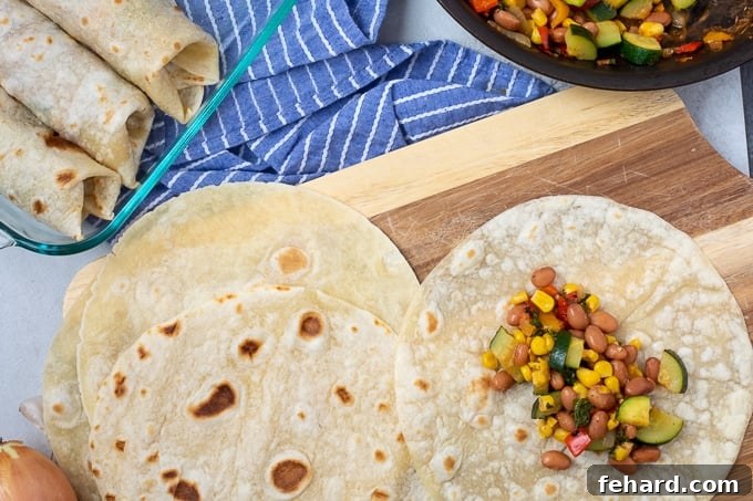 Tortilla with vegetable and bean mixture on cutting board. 