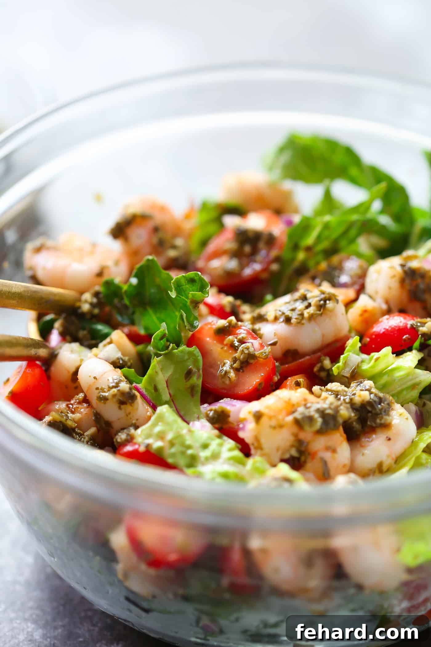 Close-up of a portion of Pesto Shrimp Tomato Salad showcasing the plump shrimp and halved cherry tomatoes.