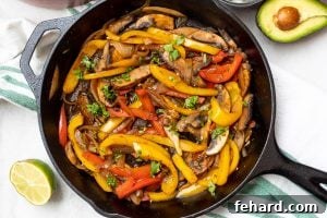 Vegetarian Fajita Mixture in cast iron skillet with lime and avocado off the side.