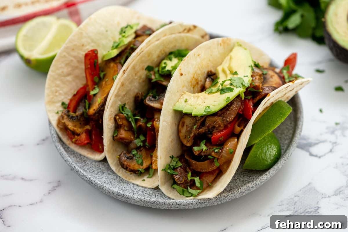 Veggie Fajita Mixture in tortillas topped with fresh avocado slices and cilantro sprigs.