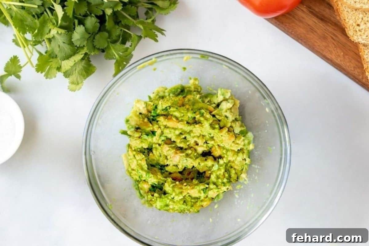 Finished Base for Avocado Chickpea Salad A bowl filled with perfectly mashed chickpeas mixed into creamy avocado, creating the base for a delightful vegan salad.