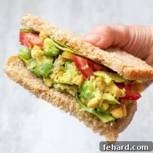 Creamy Chickpea Avocado Salad 3 Chickpea Avocado Salad on wheat bread topped with tomatoes and lettuce.