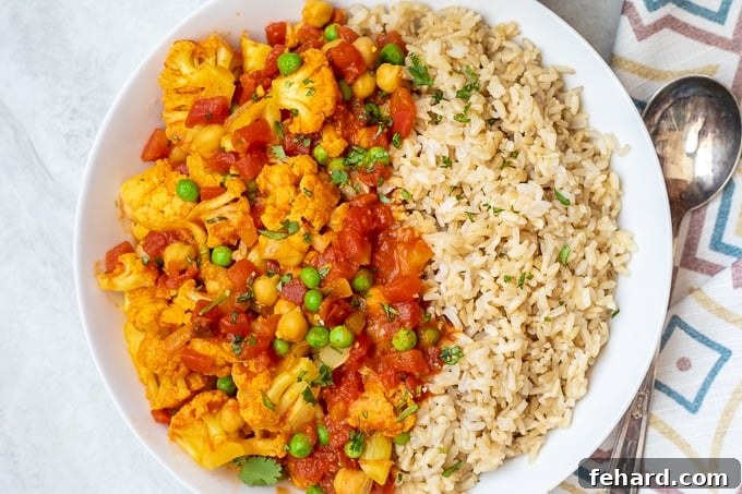 tikka masala dished up with brown rice in a white bowl..
