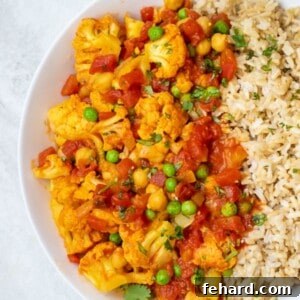 Cauliflower and chickpea tikka masala served next to brown rice.