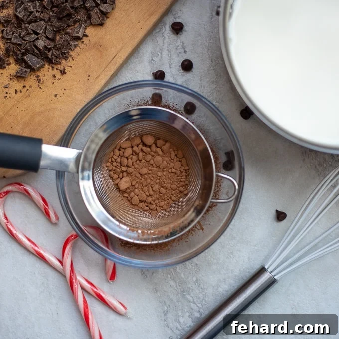 Sifting Cocoa for Hot Chocolate Cocoa powder being sifted through a fine mesh strainer into a bowl, preventing lumps.