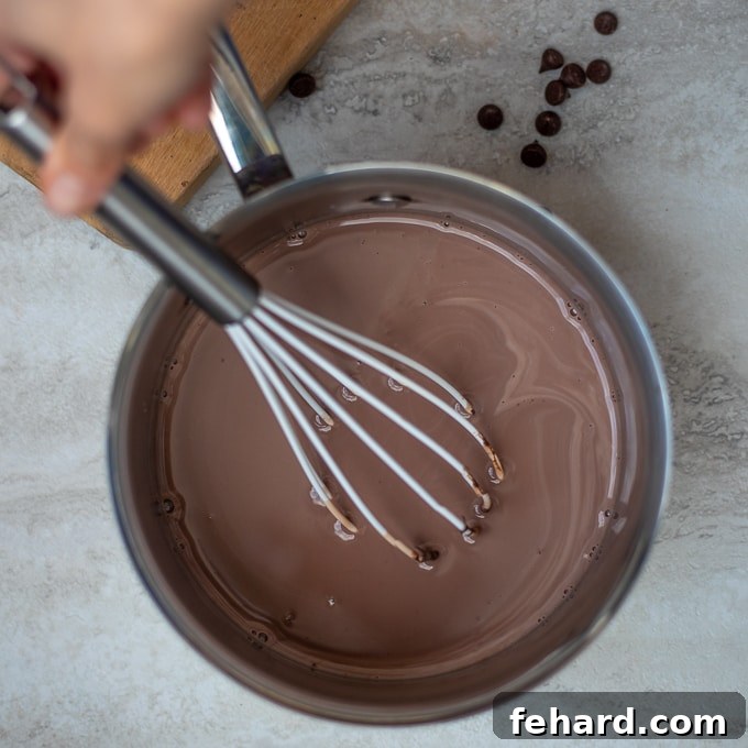 Whisking Hot Chocolate in Saucepan A whisk in a saucepan of homemade hot chocolate, showing the smooth, rich texture.
