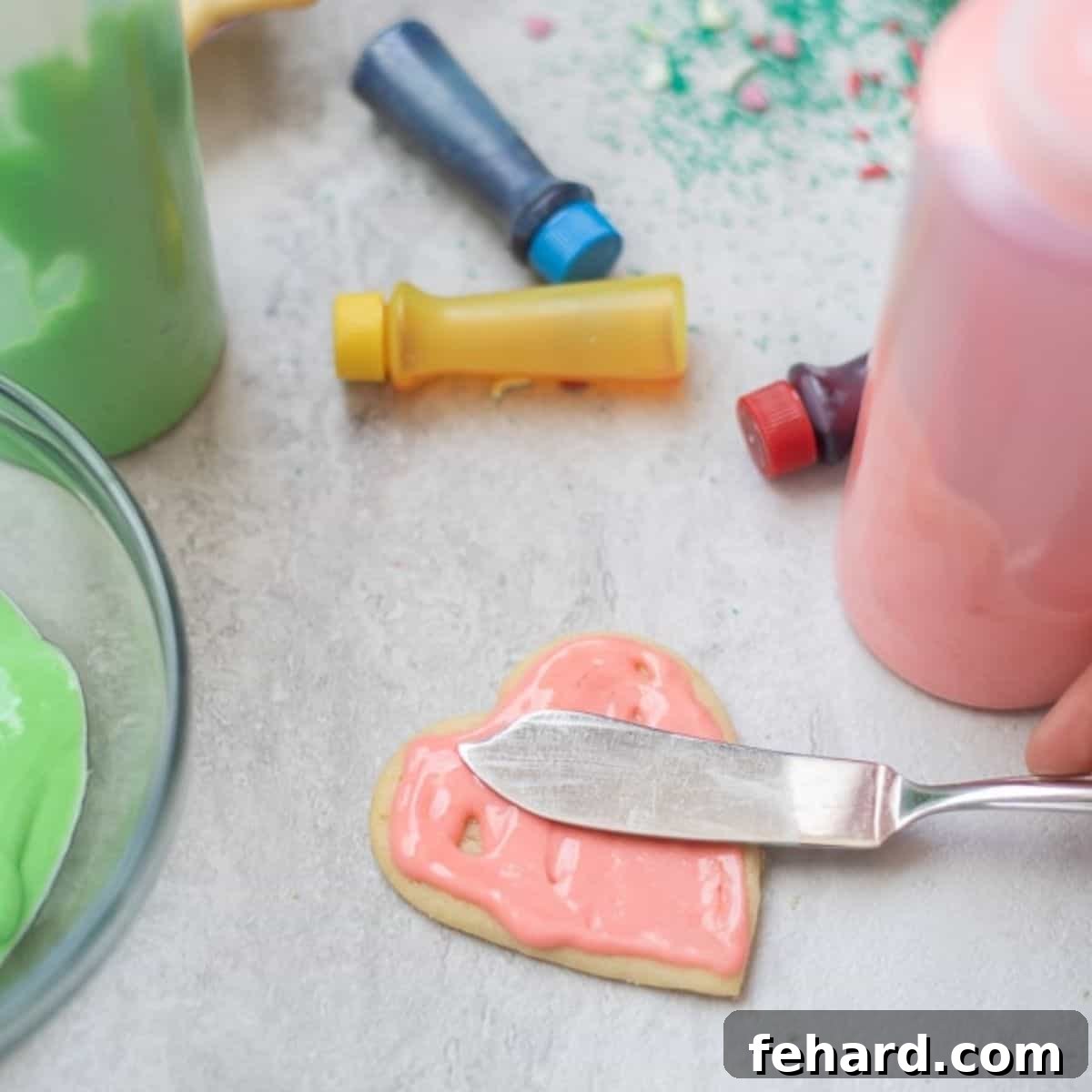Easy Sugar Cookie Frosting Spreading Technique A person's hand using a small spatula to smoothly spread cream cheese icing onto a sugar cookie, demonstrating an easy decorating technique.
