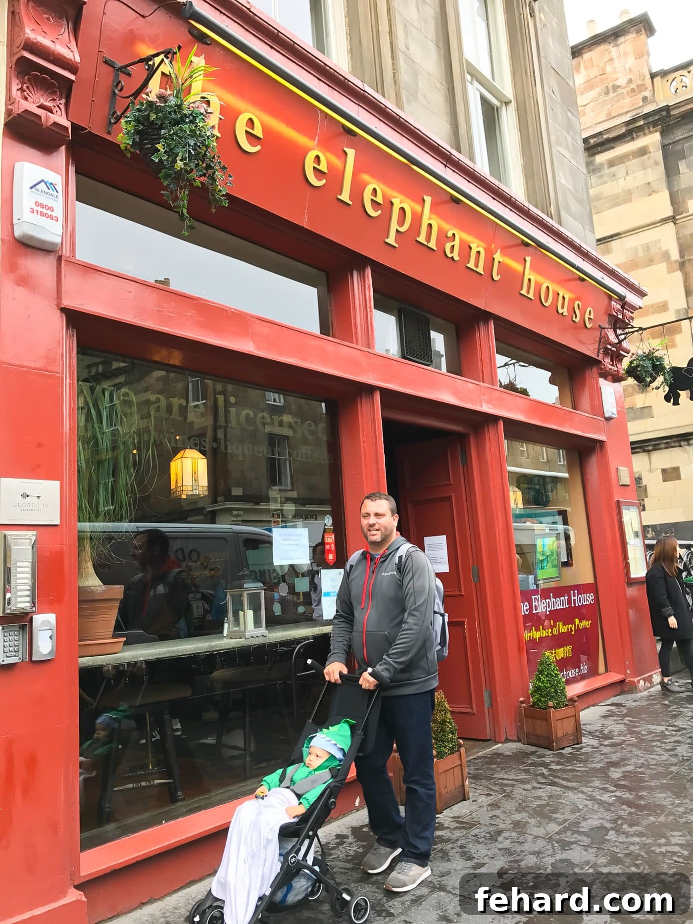 A father and his toddler in a stroller walking down a historic street in Edinburgh