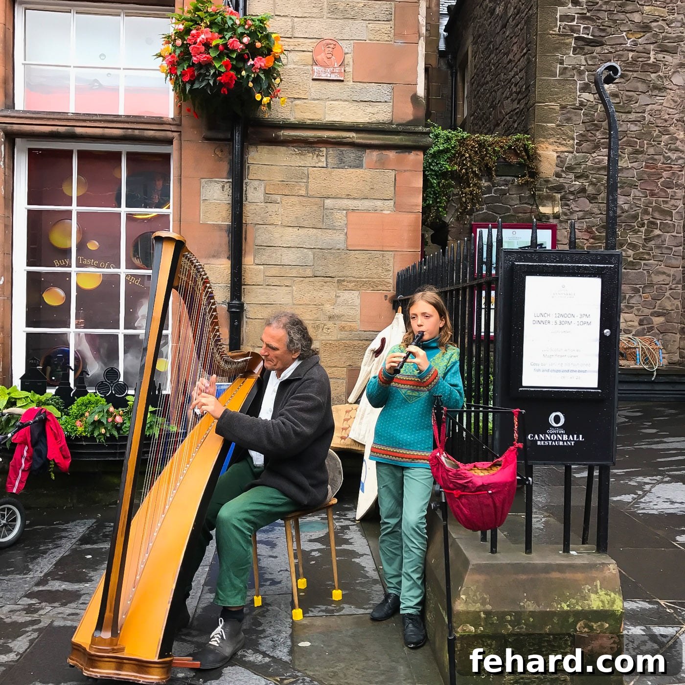 Street musicians, a man playing the flute and a girl playing the harp, entertaining passersby in Edinburgh