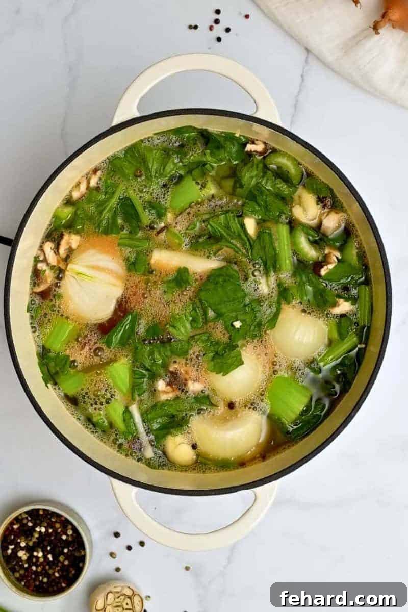 Recipe Veggie Broth Vegetable scraps simmering in water in a large pot on the stovetop, making homemade vegetable broth.