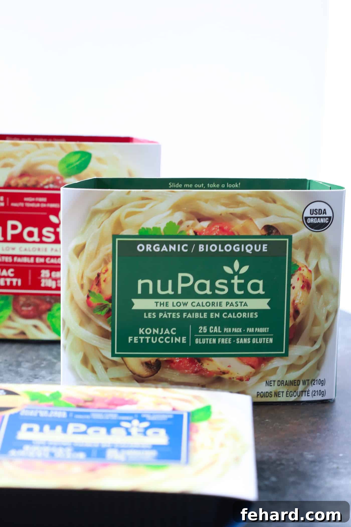 Ready to Cook: nuPasta's Versatility A bowl of vibrant Italian Sausage Sun-dried Tomato Pesto Pasta, generously topped with fresh parsley and grated Parmesan cheese. The texture of the nuPasta is perfectly complemented by the rich sauce.