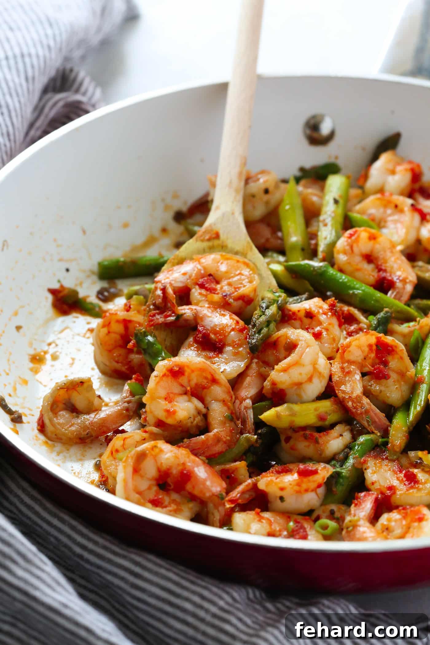 A vibrant close-up of Sun-dried Tomato Pesto Shrimp and Asparagus Skillet, showcasing juicy shrimp, bright green asparagus, and a rich red pesto sauce, ready to be served.