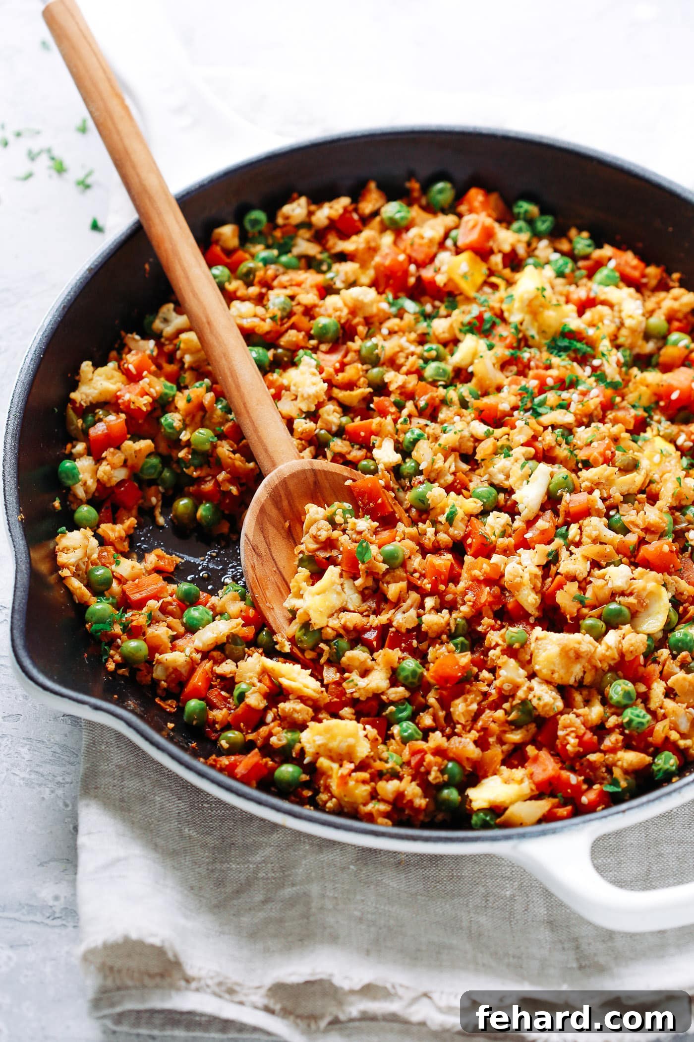 Cauliflower Fried Rice served in a bowl with chopsticks.