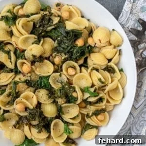Orecchiette pasta with chickpeas and kale in white dish