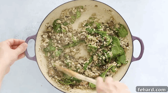 Healthy & Delicious Cauliflower Rice 7 cauliflower rice with mushroom and spinach in a skillet.