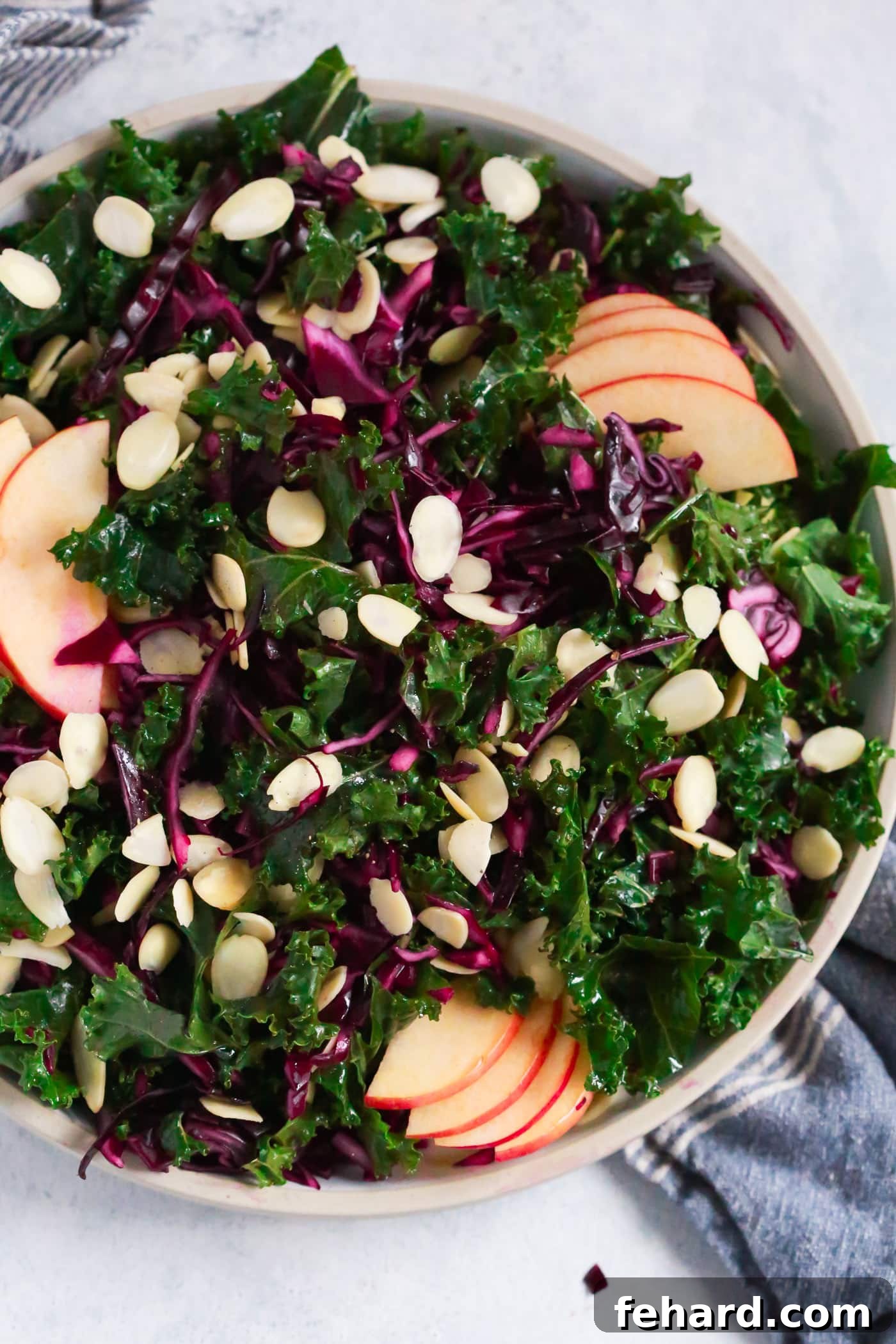 A colorful and healthy Chopped Red Cabbage Kale Salad for a nourishing meal during cold weather. Overhead photo of a large plate of vibrant chopped red cabbage kale salad, ready to be enjoyed.