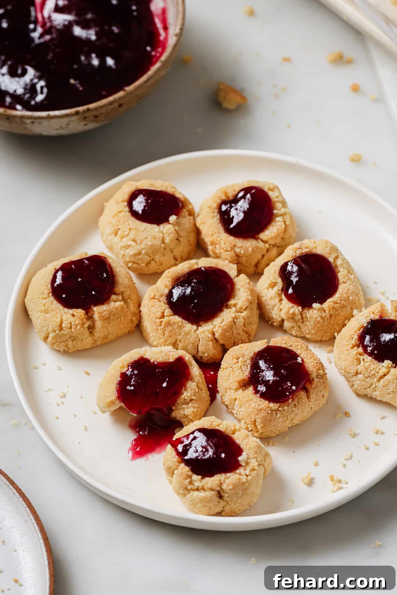Beautifully arranged Cranberry Thumbprint Cookies on a white plate, ready to be served.