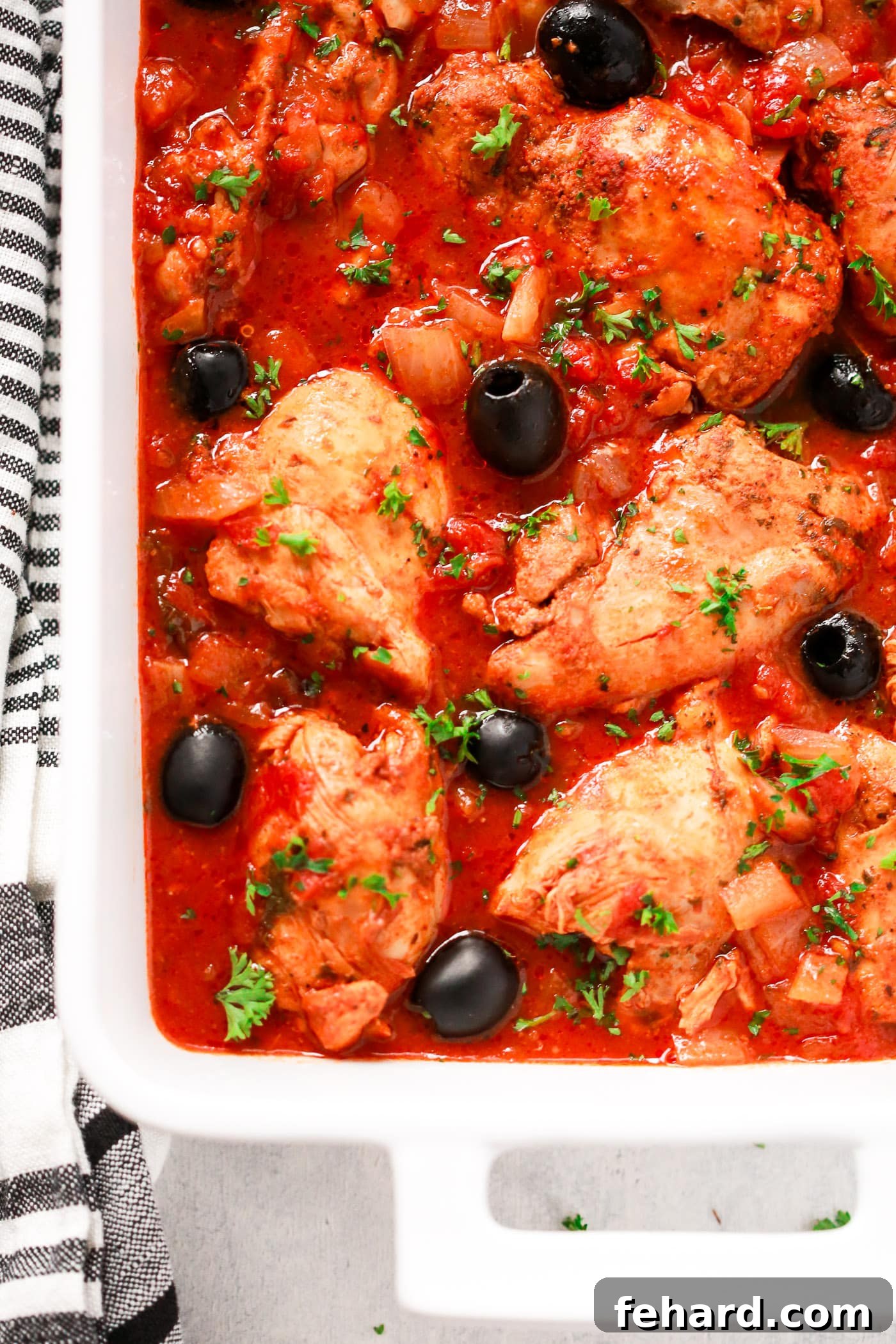 Instant Pot Mediterranean Chicken Feast 3 Close-up of succulent chicken and tomato sauce in a white serving dish, ready to be enjoyed.