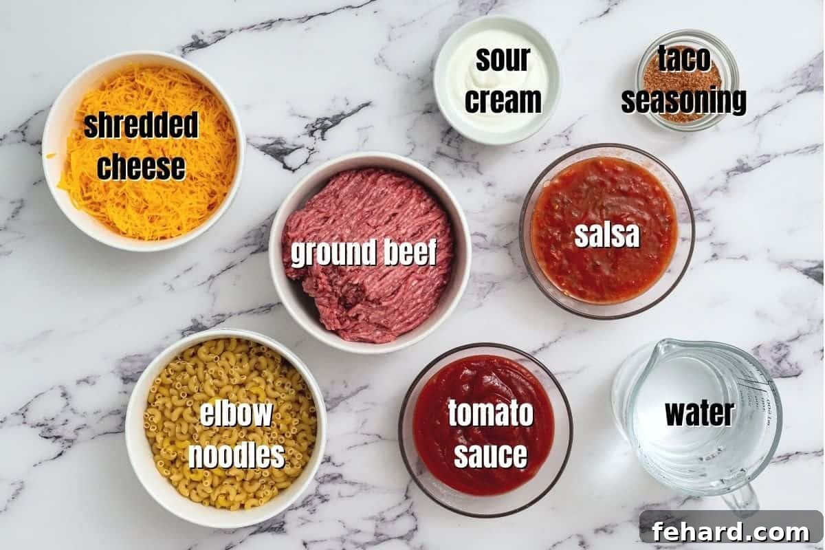 Various ingredients for making taco pasta, neatly labeled and arranged on a kitchen counter.