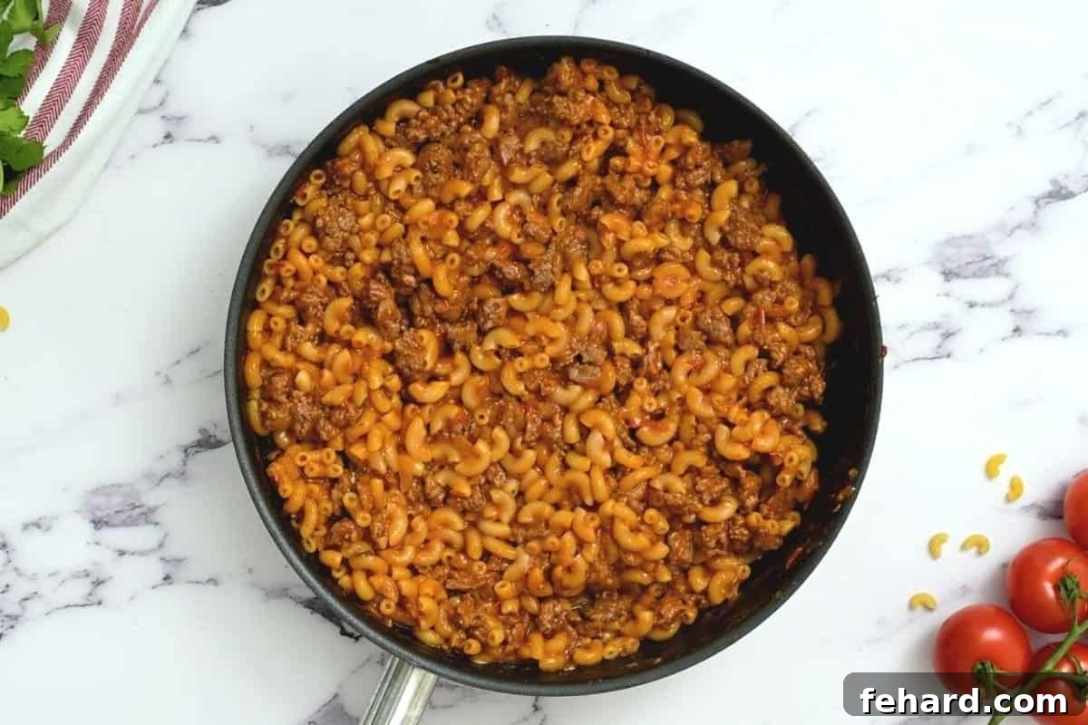 Perfectly cooked Taco Pasta simmering in a large skillet, coated in rich sauce and ready for the final touches.