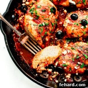 overhead view of a cast iron skillet containing Mediterranean Chicken breast