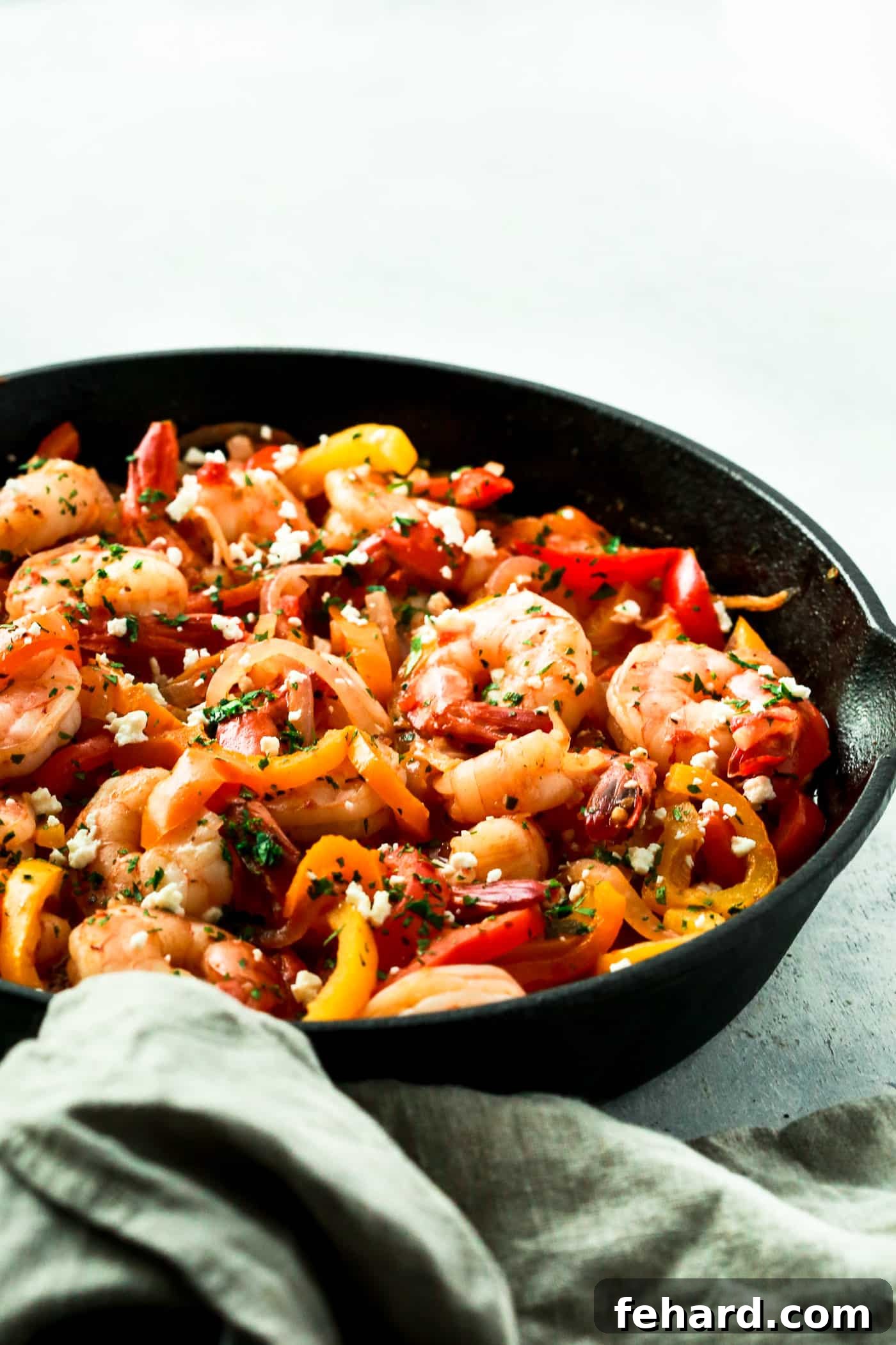 Close-up of a vibrant Shrimp, Bell Pepper and Onions Skillet cooking in a cast iron pan.