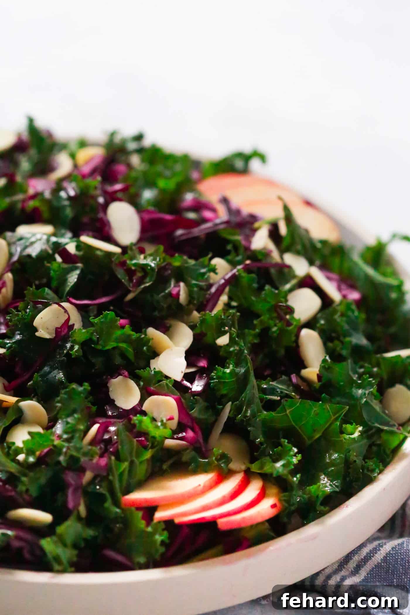 Close-up view of a hearty chopped red cabbage and kale salad in a grey bowl.