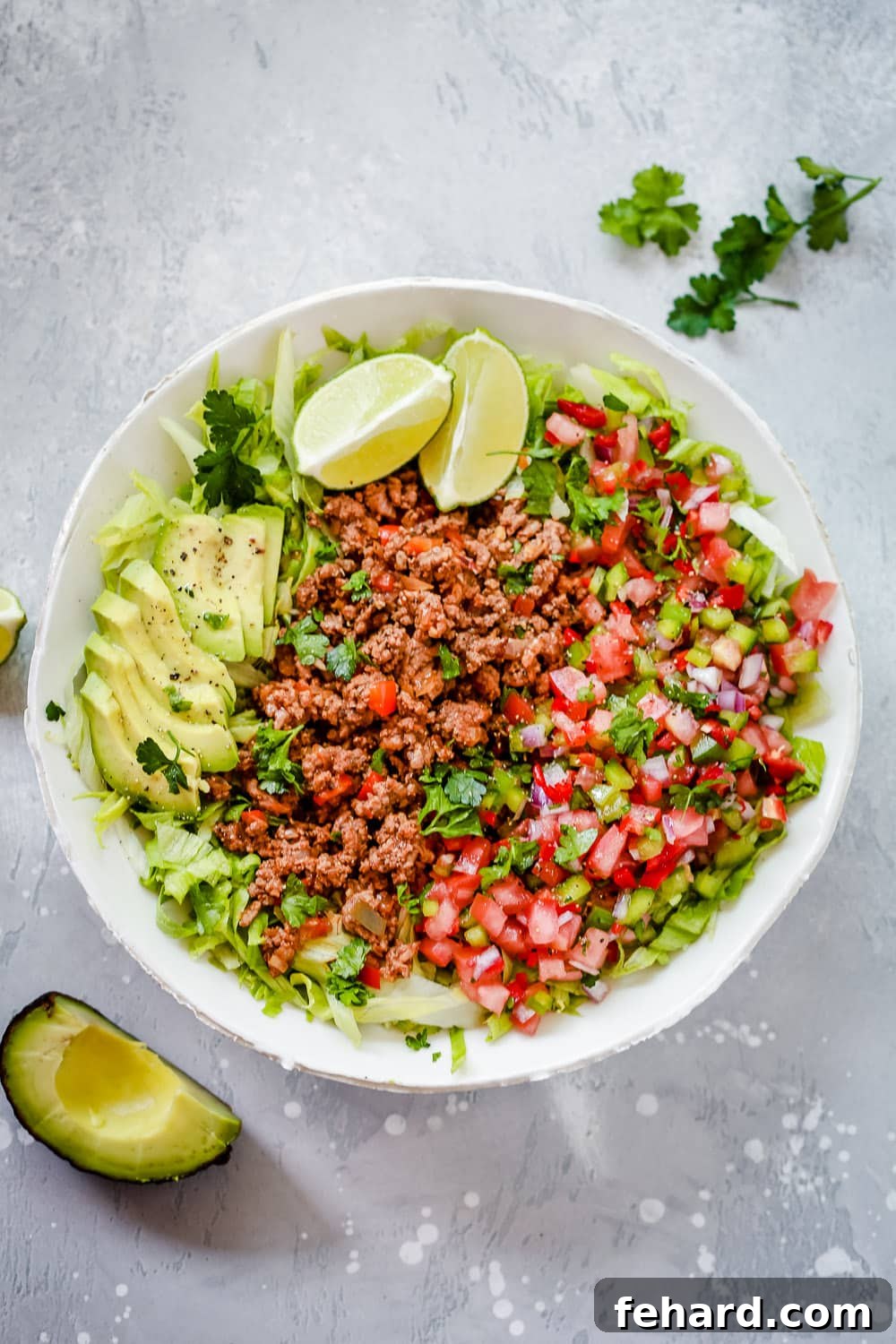 An overhead photo of a white plate generously filled with a ground beef keto taco salad.