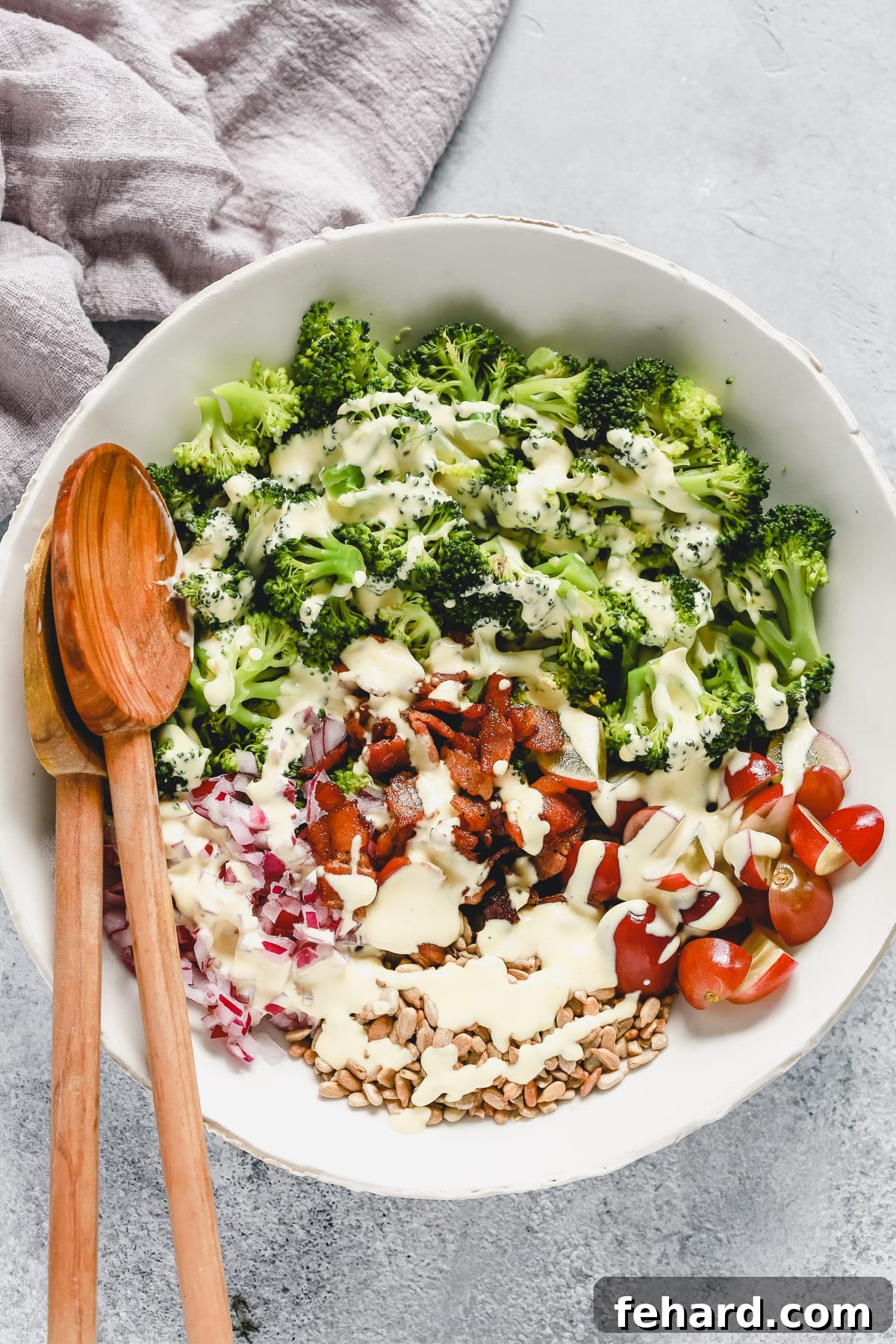 A large bowl filled with fresh keto broccoli salad, tossed with a creamy dressing and savory additions.