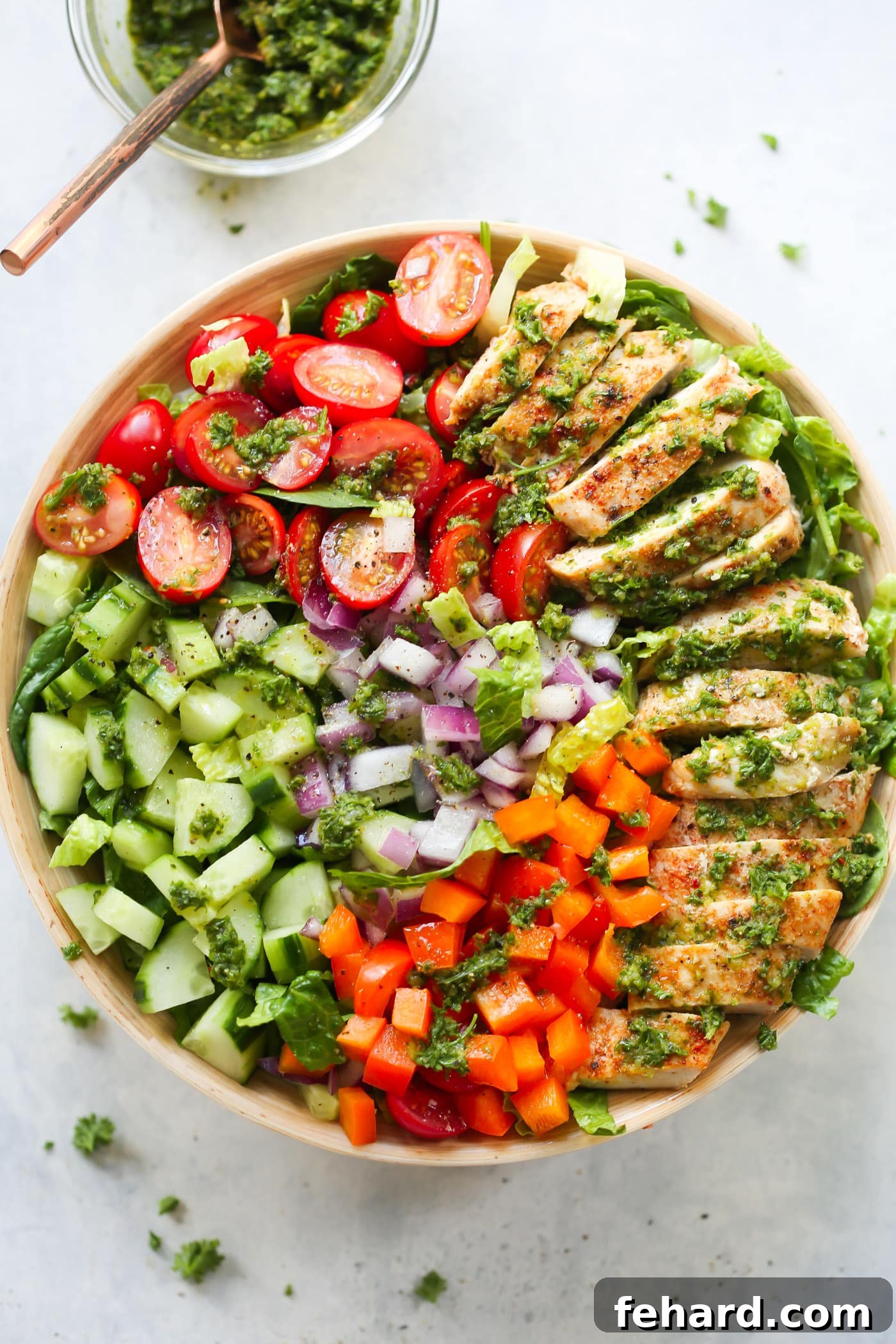 Overhead view of a chimichurri chicken chopped salad bowl, featuring grilled chicken and fresh vegetables.