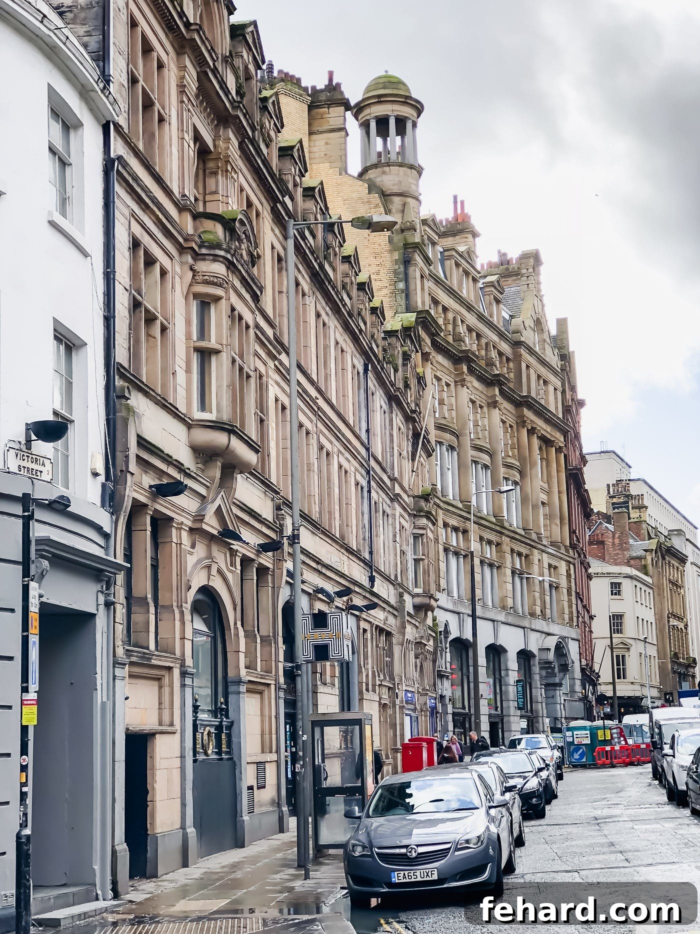 A wide view of a street in Liverpool, featuring elegant buildings and a vibrant urban atmosphere