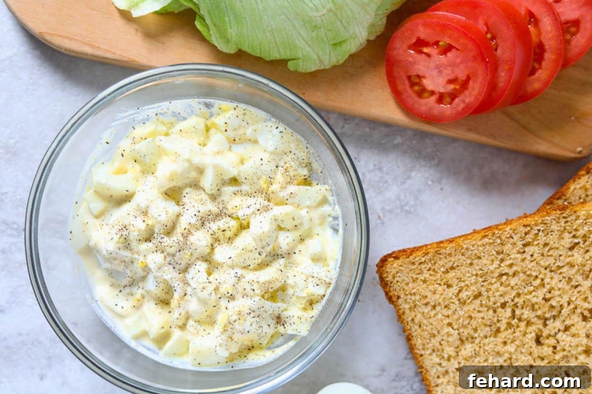 Egg Salad with Horseradish Freshly made egg salad with mayonnaise, pepper, and horseradish in a mixing bowl, ready to be chilled.