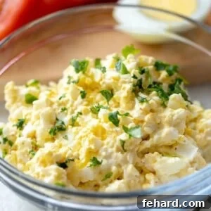 A bowl of egg salad topped with fresh parsley, ready to be served.