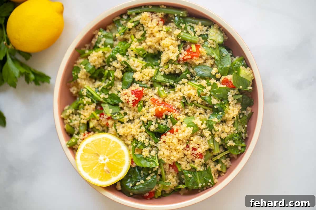 A vibrant bowl of Quinoa Salad featuring fresh spinach, sweet roasted red peppers, and a hint of lemon, beautifully garnished and ready to be served as a healthy and satisfying meal.