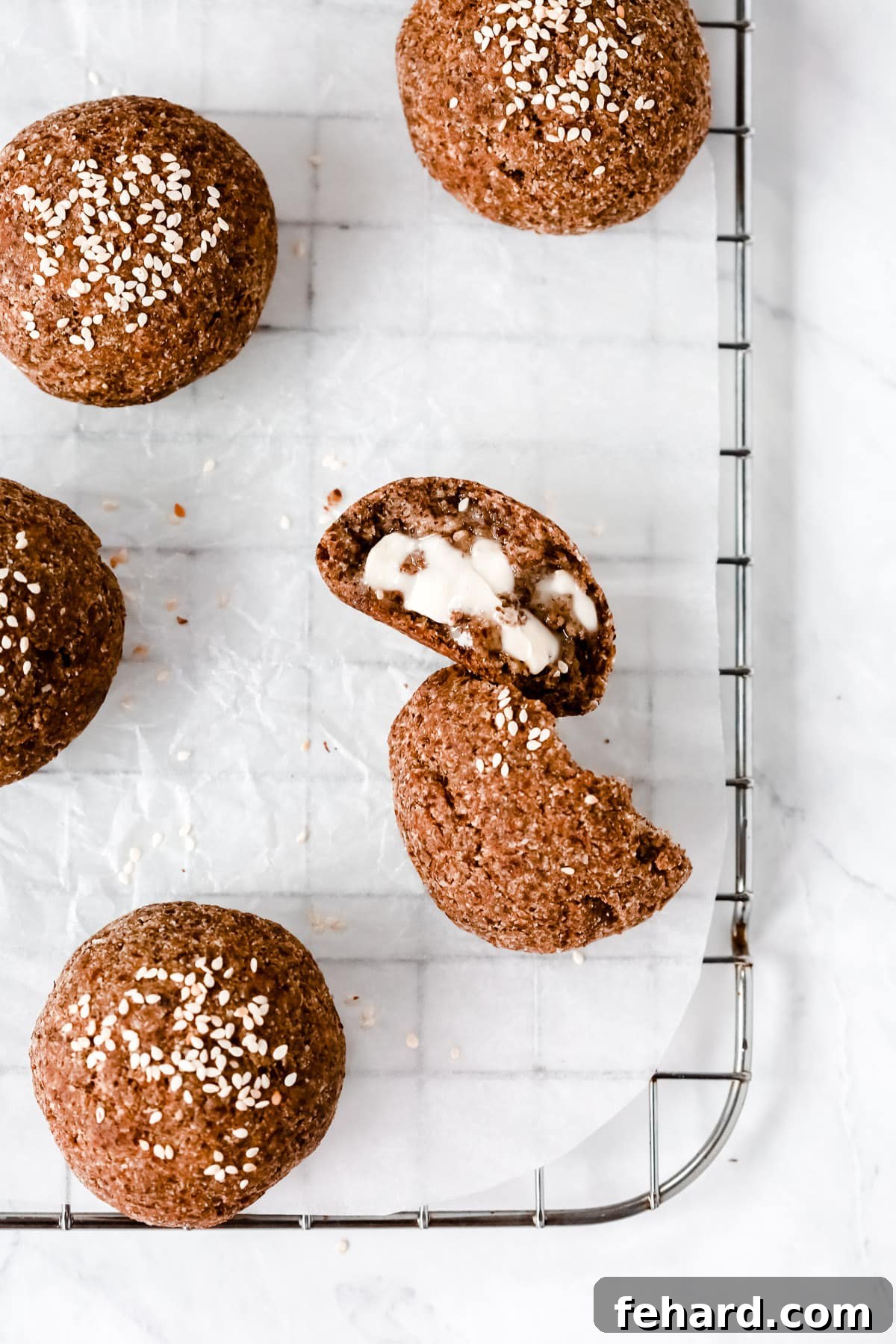 Fluffy Keto Dinner Rolls 2 Overhead photo of a dinner roll cut opened on a cooling rack.