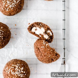 Overhead photo of a dinner roll cut opened on a cooling rack.