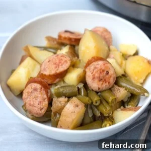 A side shot of a bowl of Instant Pot Kielbasa, Potatoes, and Green Beans, perfectly cooked.