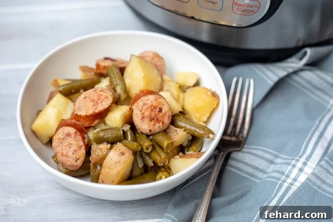 Ready-to-Serve Smoked Sausage and Potatoes A close-up of a white bowl filled with the finished Instant Pot Smoked Sausage and Potatoes with Green Beans, showcasing the tender ingredients.
