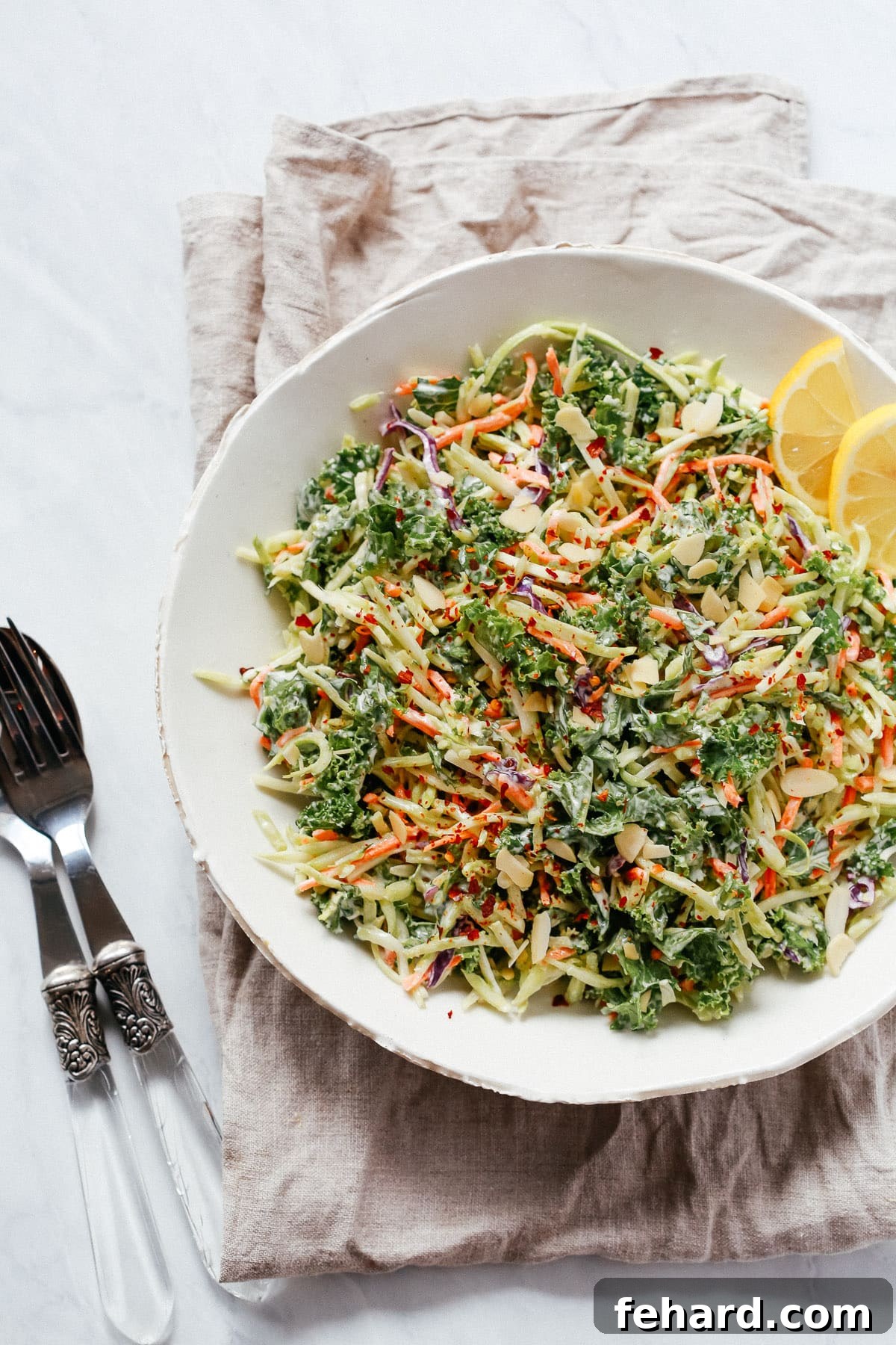 Overhead photo of a white plate of broccoli kale slaw salad, ready to serve.