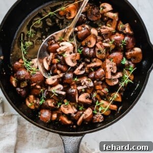 Sizzling Garlic Butter Mushrooms 4 Overhead photo of a cast iron pan with garlic butter mushrooms inside.